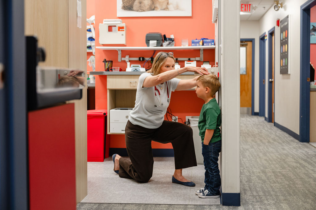 a pediatrician measuring the height of a young boy