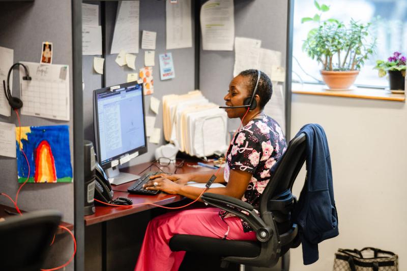 a woman sitting at a computer with a phone headset